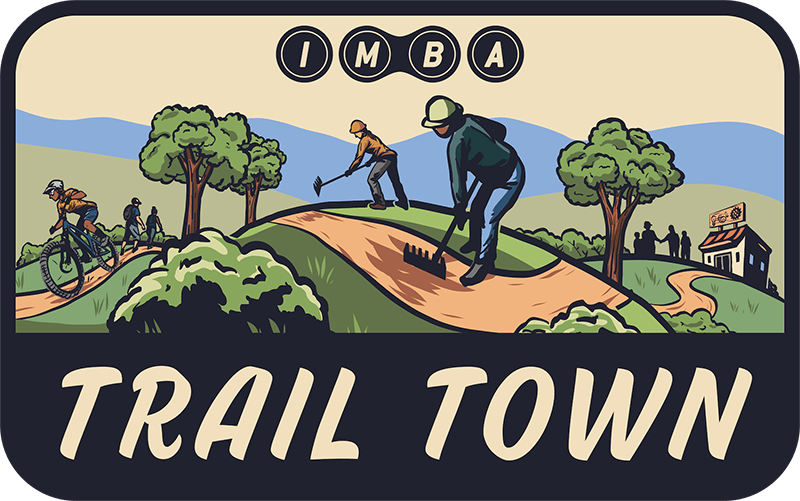 Official IMBA Trail Town logo illustration showing volunteers working on mountain biking trails in Warren County PA.