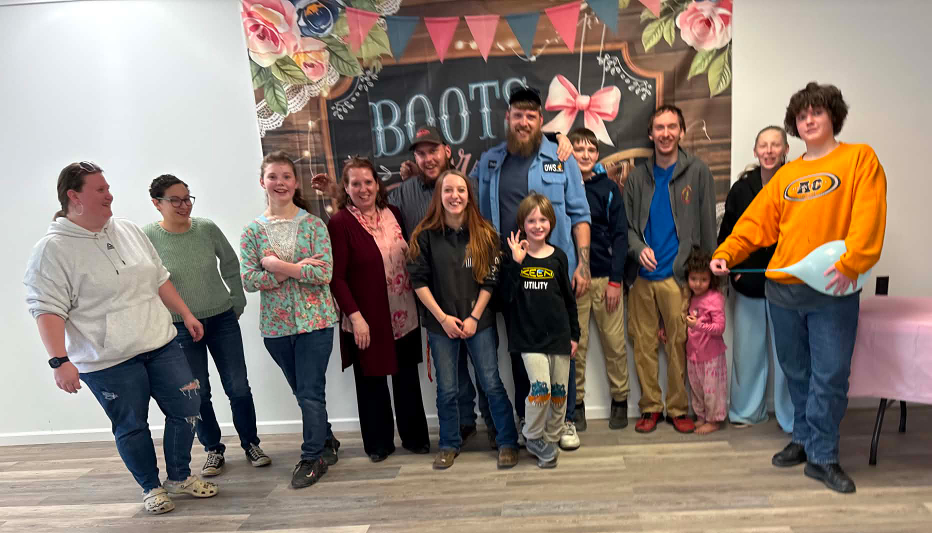 A smiling group of community members, families, and children standing together at a Bee Courageous @ Garden Grub gathering.